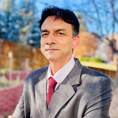 man with dark hair wearing a suit with a red tie